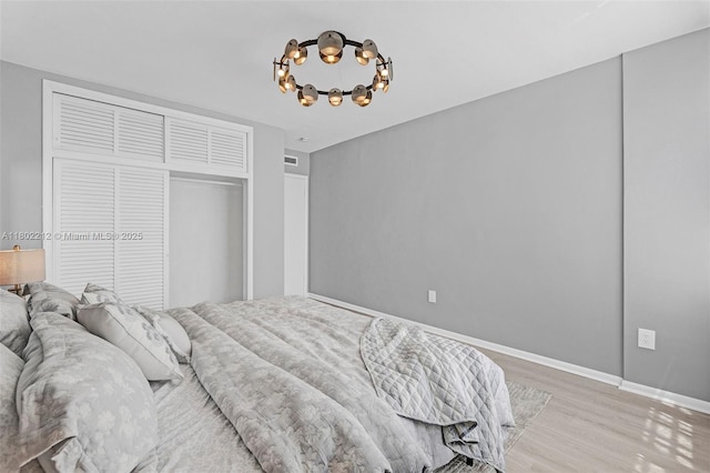 1150 Euclid Ave Unit 305, Miami Beach, FL 33139 - bedroom with a chandelier, light wood finished floors, and a closet