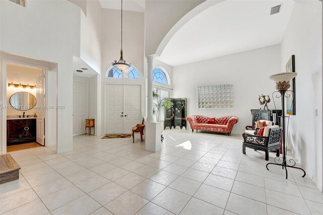 5957 NW 125th Ave, Coral Springs, FL 33076 - entryway featuring arched walkways, a high ceiling, light tile patterned floors, and ornate columns