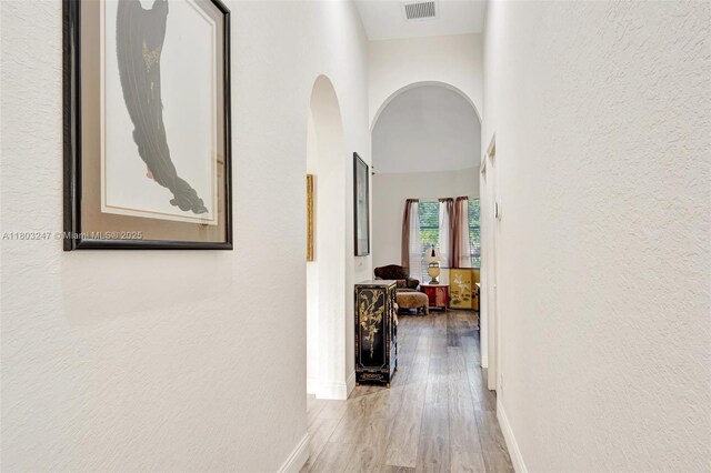 5957 NW 125th Ave, Coral Springs, FL 33076 - hallway with arched walkways, wood finished floors, baseboards, and a textured wall