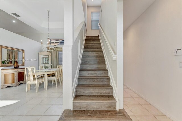 5957 NW 125th Ave, Coral Springs, FL 33076 - stairs with tile patterned floors and a chandelier