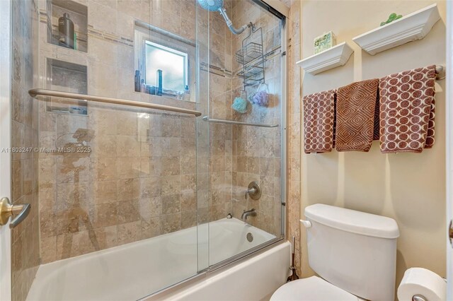 5957 NW 125th Ave, Coral Springs, FL 33076 - bathroom featuring toilet and bath / shower combo with glass door