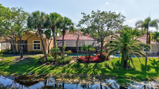 5957 NW 125th Ave, Coral Springs, FL 33076 - back of property featuring a lawn, stucco siding, and a water view