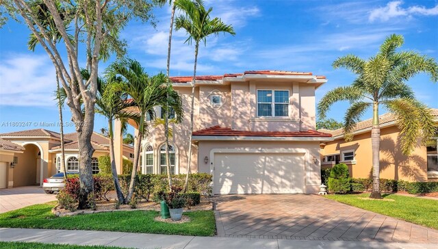 5957 NW 125th Ave, Coral Springs, FL 33076 - mediterranean / spanish-style house with stucco siding, driveway, a tiled roof, and an attached garage
