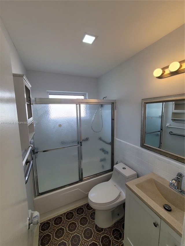 4519 NW 49th Dr, Tamarac, FL 33319 - full bathroom with tile walls, combined bath / shower with glass door, toilet, vanity, and wainscoting