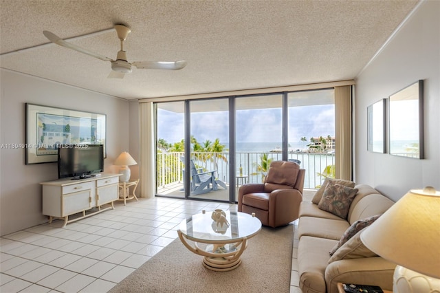 2000 Coco Plum Dr Unit 301, Marathon, FL 33050 - living room with a water view, ceiling fan, a textured ceiling, light tile patterned floors, and expansive windows