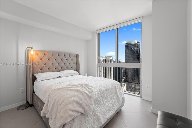 1100 S Miami Ave Unit 3210, Miami, FL 33130 - bedroom featuring a city view, baseboards, a wall of windows, and light tile patterned flooring