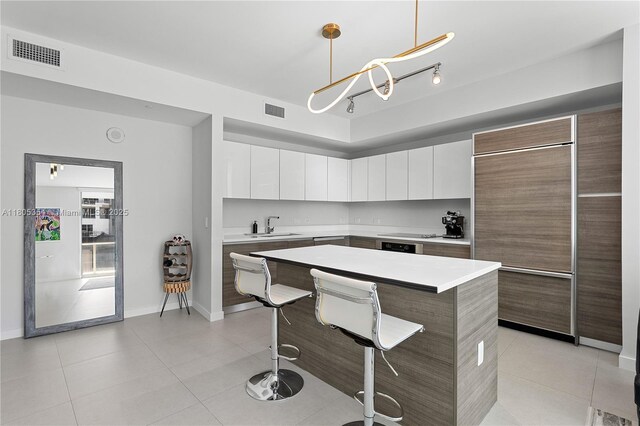 1100 S Miami Ave Unit 3210, Miami, FL 33130 - kitchen with paneled built in refrigerator, a kitchen breakfast bar, light tile patterned flooring, and light countertops