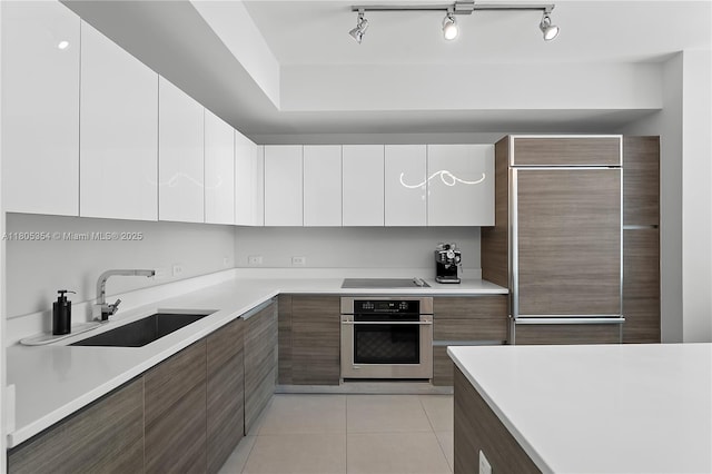 1100 S Miami Ave Unit 3210, Miami, FL 33130 - kitchen with oven, modern cabinets, a sink, paneled refrigerator, and black electric stovetop