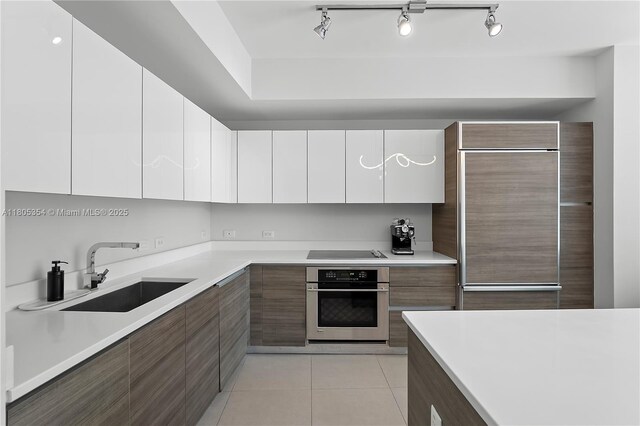 1100 S Miami Ave Unit 3210, Miami, FL 33130 - kitchen featuring oven, modern cabinets, built in refrigerator, black electric stovetop, and white cabinets