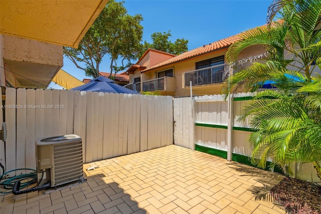 view of patio / terrace featuring central AC unit and fence