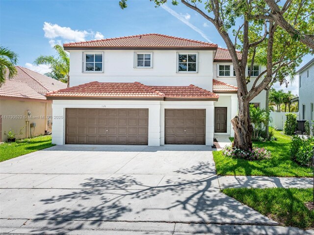 1128 Hidden Valley Way, Weston, FL 33327 - mediterranean / spanish-style home with concrete driveway, stucco siding, an attached garage, and a tile roof