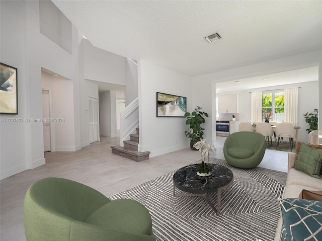 1128 Hidden Valley Way, Weston, FL 33327 - living area featuring stairway, a textured ceiling, light tile patterned floors, and baseboards