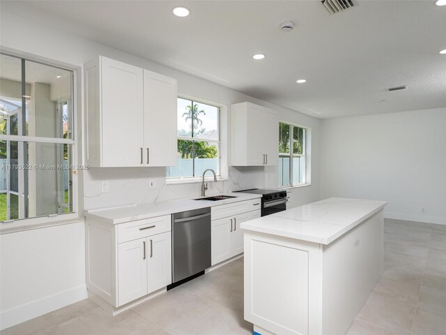 1128 Hidden Valley Way, Weston, FL 33327 - kitchen featuring dishwasher, a sink, a center island, light stone countertops, and white cabinetry