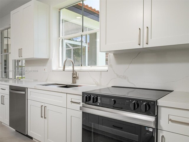 1128 Hidden Valley Way, Weston, FL 33327 - kitchen with range with electric stovetop, dishwasher, white cabinetry, and a sink
