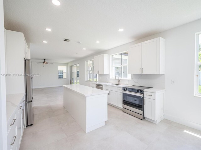 1128 Hidden Valley Way, Weston, FL 33327 - kitchen with appliances with stainless steel finishes, a sink, a center island, recessed lighting, and light countertops