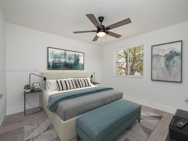 1128 Hidden Valley Way, Weston, FL 33327 - bedroom featuring baseboards, light wood-style floors, a textured ceiling, and ceiling fan