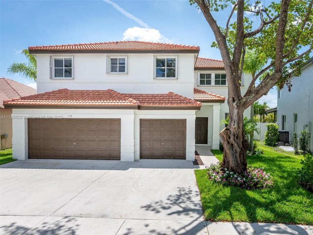 1128 Hidden Valley Way, Weston, FL 33327 - mediterranean / spanish-style house featuring a garage, concrete driveway, a tiled roof, and stucco siding