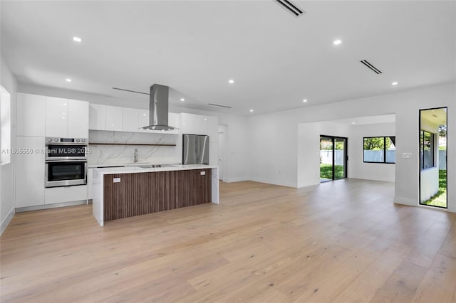 53 NW 107th St, Miami Shores, FL 33168 - kitchen featuring island range hood, modern cabinets, stainless steel appliances, white cabinets, and open floor plan