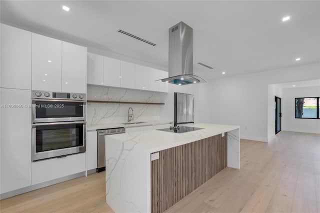 53 NW 107th St, Miami Shores, FL 33168 - kitchen featuring appliances with stainless steel finishes, island exhaust hood, modern cabinets, white cabinetry, and light wood-style floors