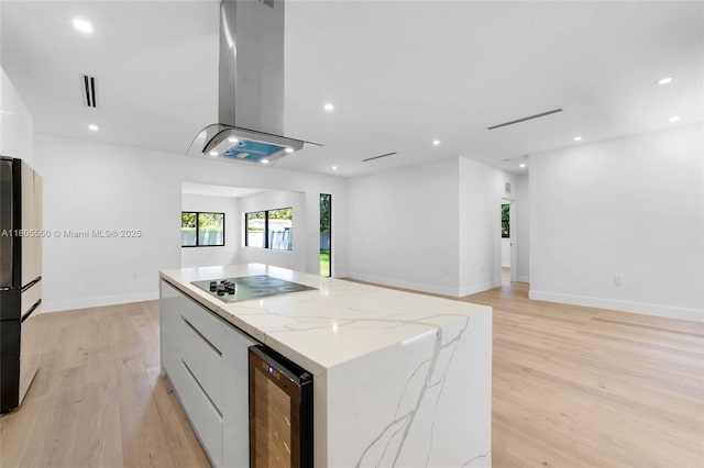 53 NW 107th St, Miami Shores, FL 33168 - kitchen with wine cooler, black electric stovetop, island range hood, modern cabinets, and a kitchen island