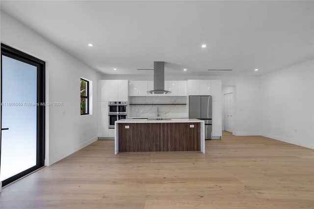 53 NW 107th St, Miami Shores, FL 33168 - kitchen featuring island range hood, appliances with stainless steel finishes, modern cabinets, white cabinetry, and a kitchen island