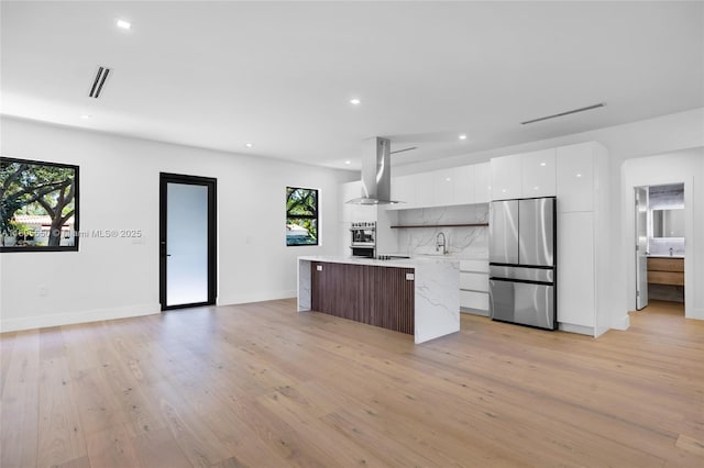 53 NW 107th St, Miami Shores, FL 33168 - kitchen featuring appliances with stainless steel finishes, range hood, modern cabinets, a kitchen island, and white cabinets