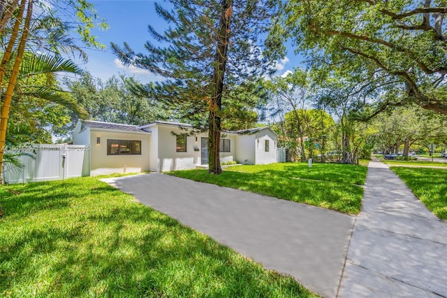 53 NW 107th St, Miami Shores, FL 33168 - view of front of home with stucco siding, asphalt driveway, and a gate