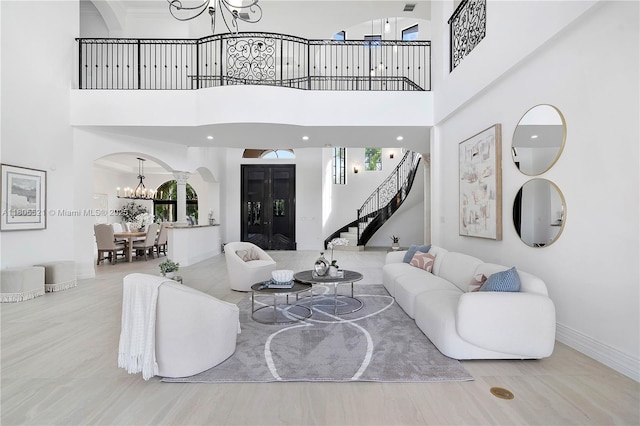 11930 NW 8th St, Plantation, FL 33325 - living area with a chandelier, arched walkways, stairs, a high ceiling, and baseboards