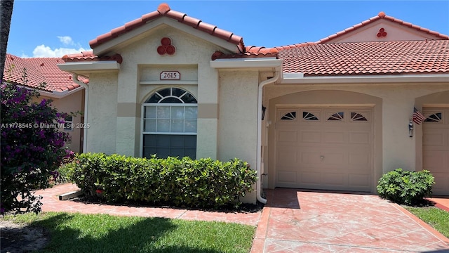 2615 Spiceberry Ln Unit 2625, Boynton Beach, FL 33436 - view of front of house with a tile roof, a garage, stucco siding, and driveway