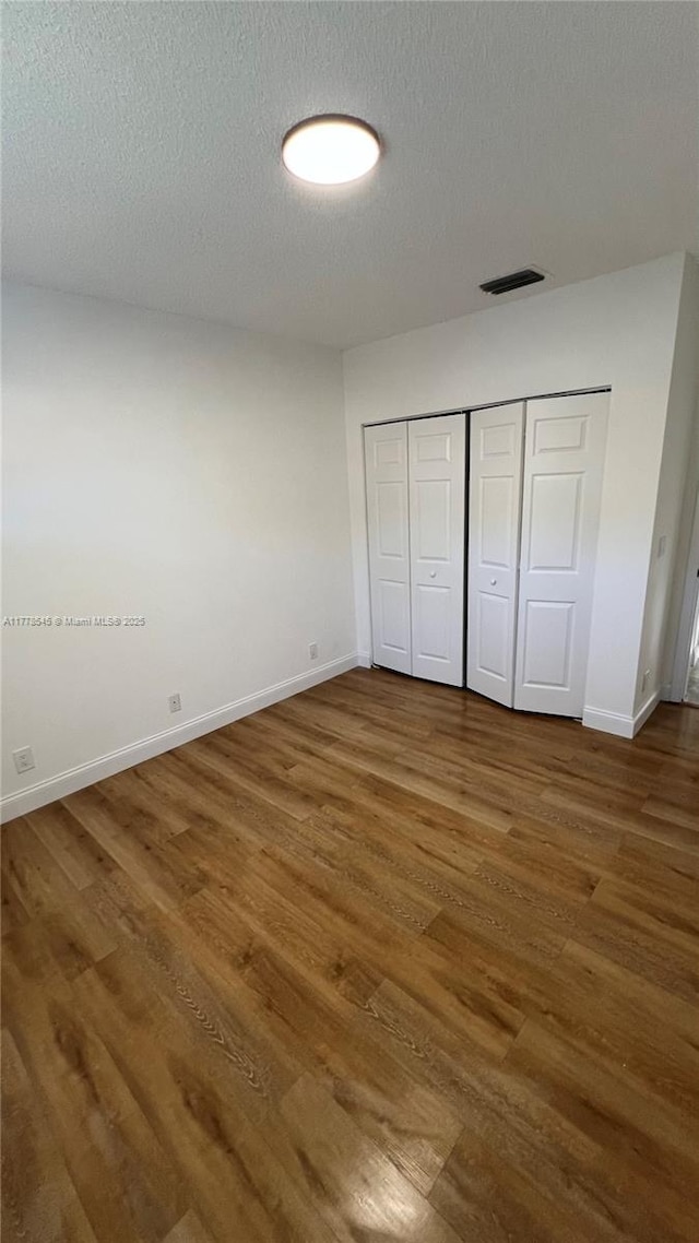 2615 Spiceberry Ln Unit 2625, Boynton Beach, FL 33436 - unfurnished bedroom featuring wood finished floors, a textured ceiling, and a closet