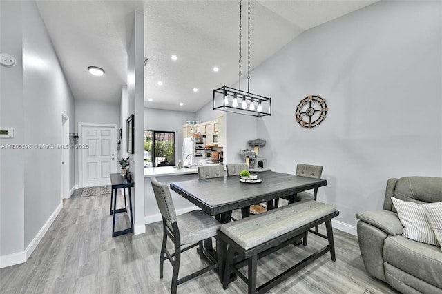 1054 NW 53rd St, Deerfield Beach, FL 33064 - dining room with baseboards, light wood-style floors, vaulted ceiling, and recessed lighting