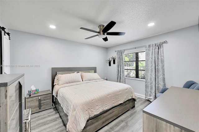1054 NW 53rd St, Deerfield Beach, FL 33064 - bedroom with light wood finished floors, recessed lighting, ceiling fan, a textured ceiling, and baseboards