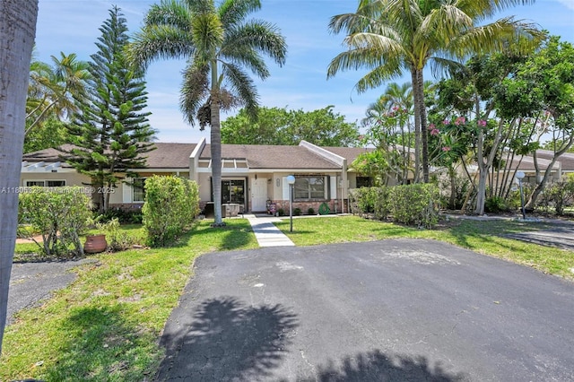 1054 NW 53rd St, Deerfield Beach, FL 33064 - view of front facade with a front yard and stucco siding
