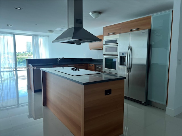 2950 NE 188th St Unit 444, Aventura, FL 33180 - kitchen featuring appliances with stainless steel finishes, island exhaust hood, dark countertops, light tile patterned floors, and a center island