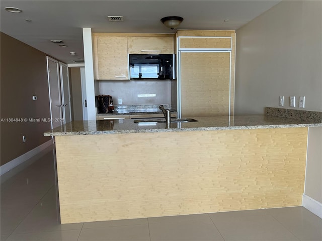 1800 S Ocean Dr Unit 2006, Hallandale Beach, FL 33009 - kitchen with black microwave, a sink, stone counters, a peninsula, and baseboards