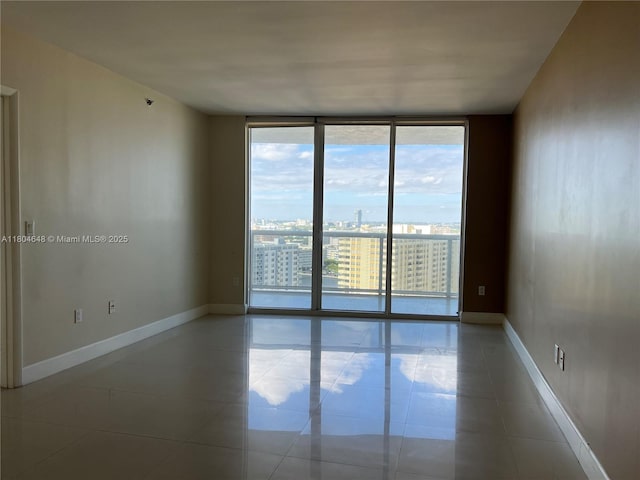 1800 S Ocean Dr Unit 2006, Hallandale Beach, FL 33009 - tiled empty room featuring floor to ceiling windows, baseboards, and a view of city