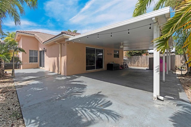 16401 SW 94th St, Miami, FL 33196 - back of house featuring a tile roof, stucco siding, a carport, fence, and concrete driveway