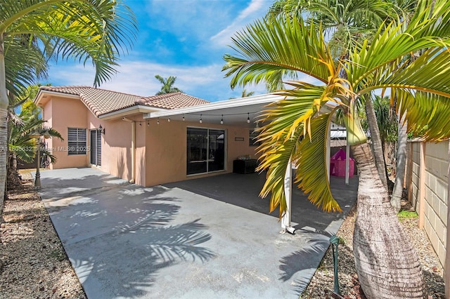 16401 SW 94th St, Miami, FL 33196 - back of property featuring stucco siding, a tiled roof, fence, and a patio