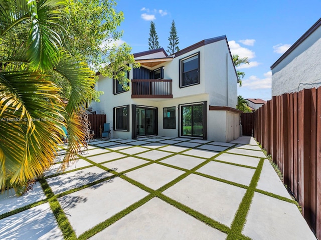 452 NW 97th Pl Unit 452, Miami, FL 33172 - rear view of property featuring a balcony, stucco siding, a patio, and a fenced backyard