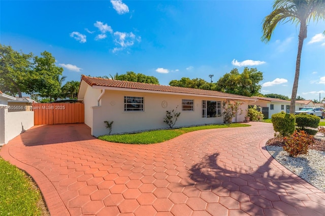 9875 SW 26th Ter, Miami, FL 33165 - view of front of home with stucco siding, a tiled roof, curved driveway, and a gate
