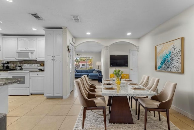 9875 SW 26th Ter, Miami, FL 33165 - dining space with arched walkways, recessed lighting, decorative columns, and light tile patterned floors
