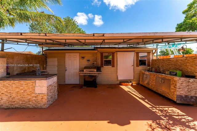 9875 SW 26th Ter, Miami, FL 33165 - view of patio / terrace with exterior kitchen and a carport