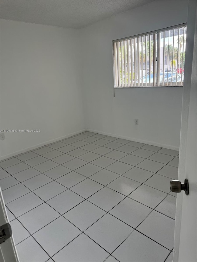 2710 W 76th St Unit 103, Hialeah, FL 33016 - spare room featuring tile patterned flooring and baseboards