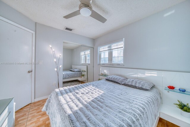 6755 NW 199th St, Hialeah, FL 33015 - bedroom featuring light wood-style flooring, a textured ceiling, a ceiling fan, and a closet