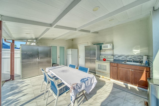 6755 NW 199th St, Hialeah, FL 33015 - kitchen featuring white appliances, light marble finish floors, beam ceiling, dark countertops, and a sink