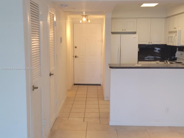 2501 S Ocean Dr Unit 1634, Hollywood, FL 33019 - kitchen with white appliances, dark countertops, light tile patterned flooring, and white cabinetry