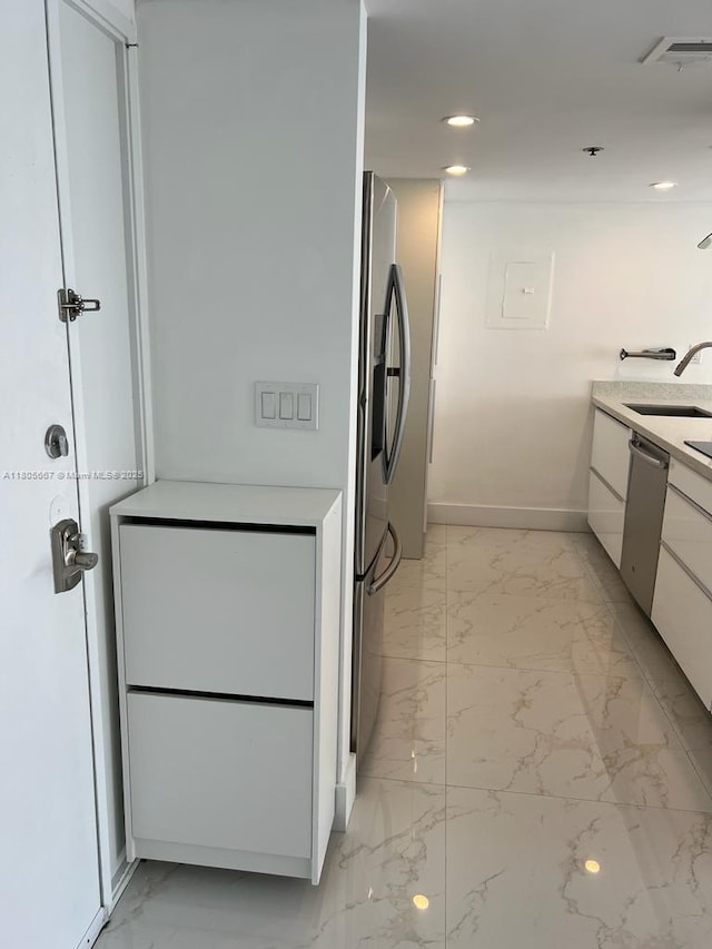 7601 E Treasure Dr Unit 1622, North Bay Village, FL 33141 - kitchen featuring appliances with stainless steel finishes, a sink, white cabinetry, light marble finish floors, and baseboards