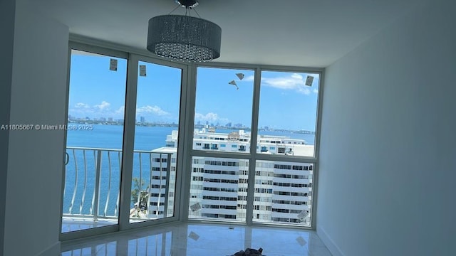 7601 E Treasure Dr Unit 1622, North Bay Village, FL 33141 - empty room featuring expansive windows, a water view, and baseboards