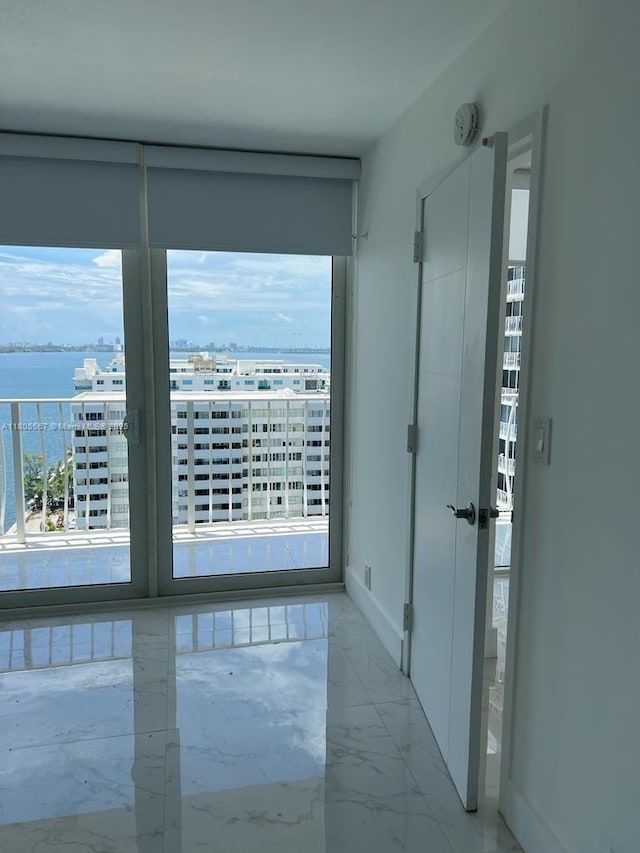 7601 E Treasure Dr Unit 1622, North Bay Village, FL 33141 - unfurnished room with light marble finish flooring, a water view, baseboards, and a smoke detector