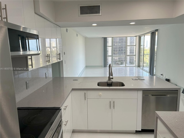 20335 W Country Club Dr Unit 903, Aventura, FL 33180 - kitchen with a sink, appliances with stainless steel finishes, plenty of natural light, white cabinetry, and recessed lighting